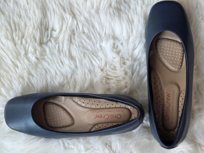 Pair of cabin crew navy blue shoes with visible brand name on a white fluffy surface + onlicrew + flydubai flat shoes