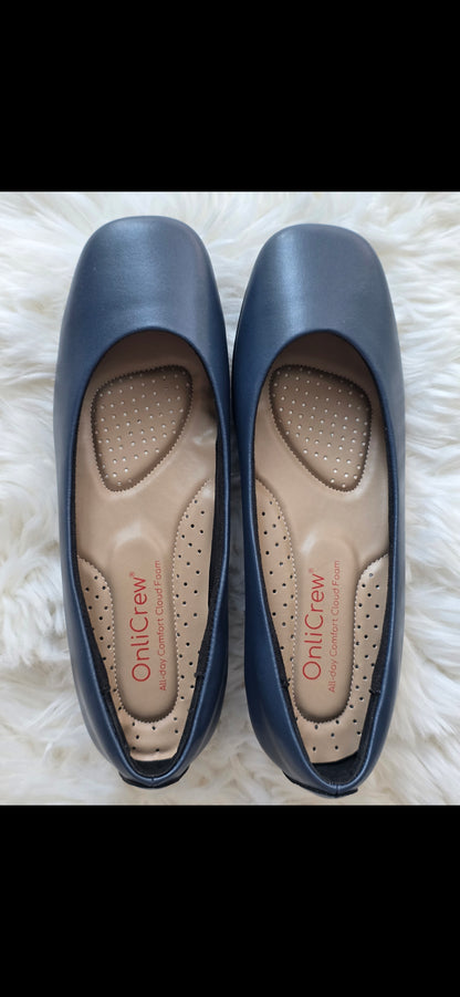 Pair of blue flats with visible brand name on a white fluffy surface + cloud foam navy blue cabin crew shoes + onlycrew onlicrew.com
